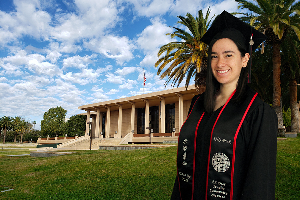 A female CSUN student poses in graduation cap and gown in front of a virtual CSUN Library background.