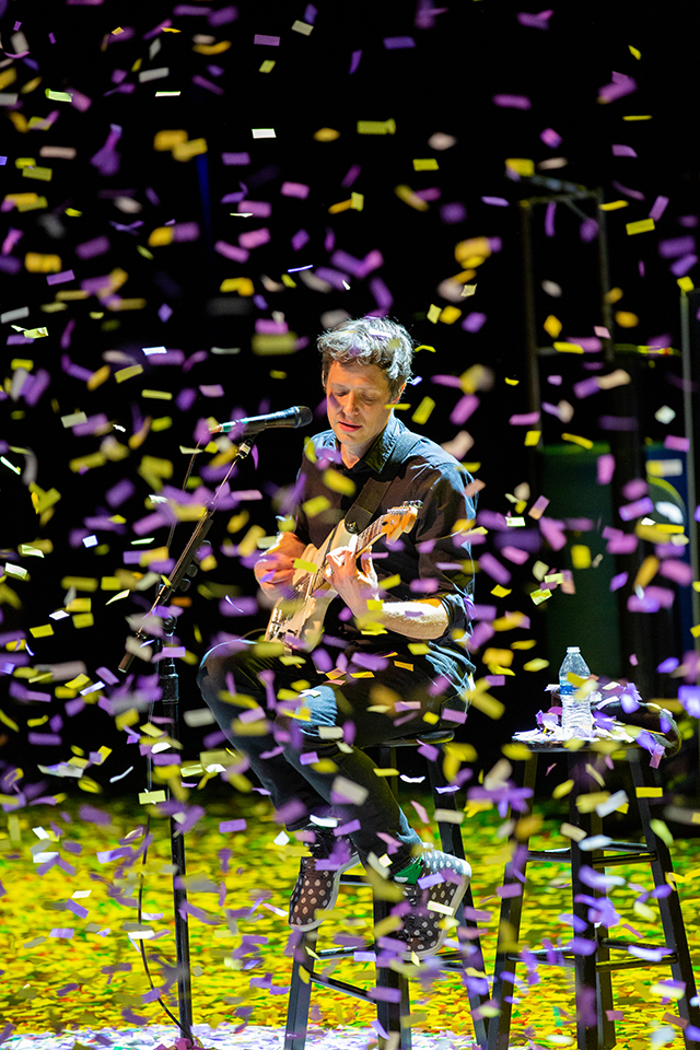 A guitarist with rock band OK Go jumps in a cloud of confetti on The Soraya stage.