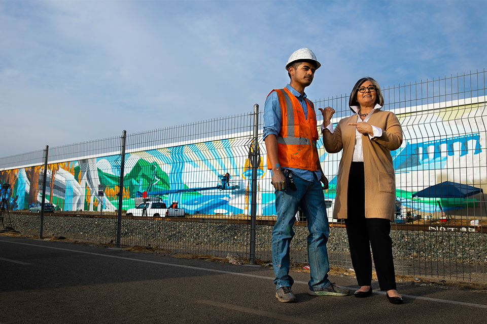 Levi Ponce with Councilwoman Monica Rodriguez on San Fernando Road in Pacoima, the site of his 10.000-square-foot mural titled "Rushing Waters." Photo by Lisa Lee.