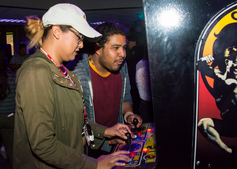 Two people playing arcade game.