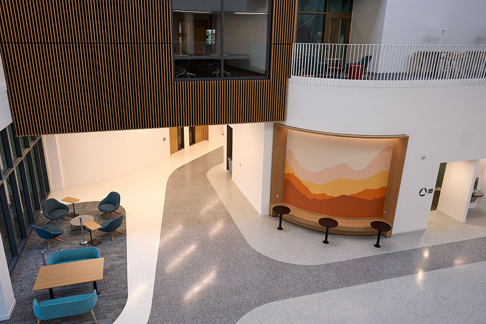 Interior photo of Maple Hall's new atrium, with seating areas pictured.