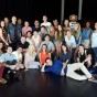 Students standing and seated post for group photo. Megan Hilty is seated with students on floor.