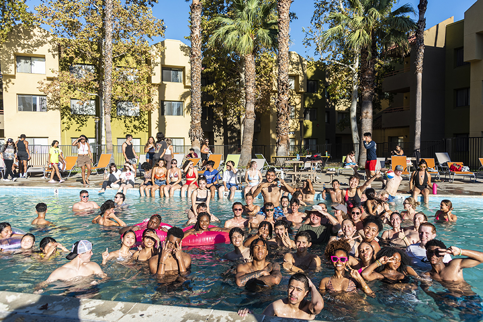 Group photo of numerous students in the pool at student residence.