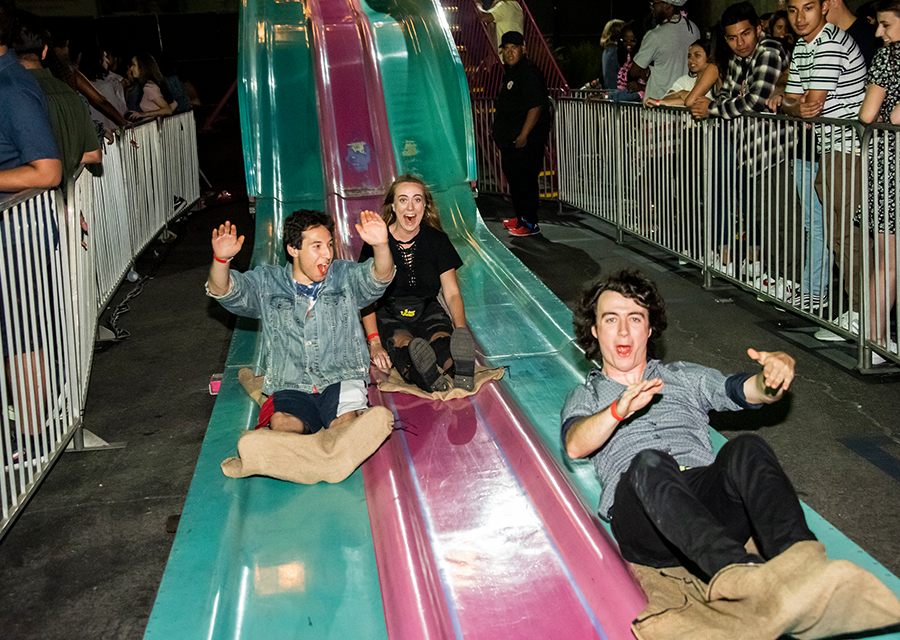 A trio of students race to the finish on slides at the University Student Union during Matador Nights on Sept. 13.