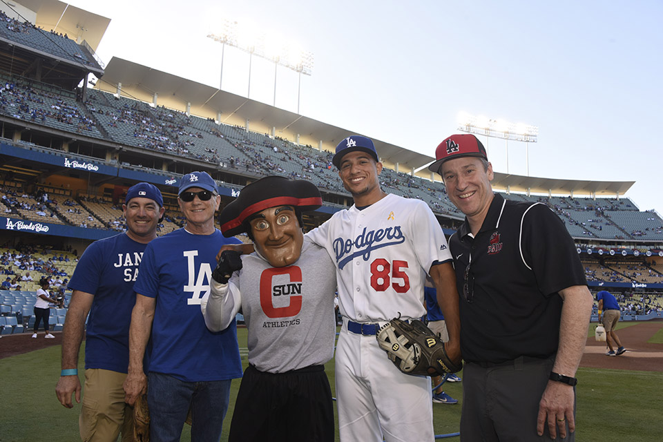 Dodger player stands for photo with CSUN alumni and faculty