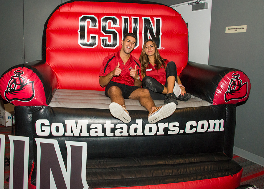 CSUN students relax in a gigantic inflatable chair.