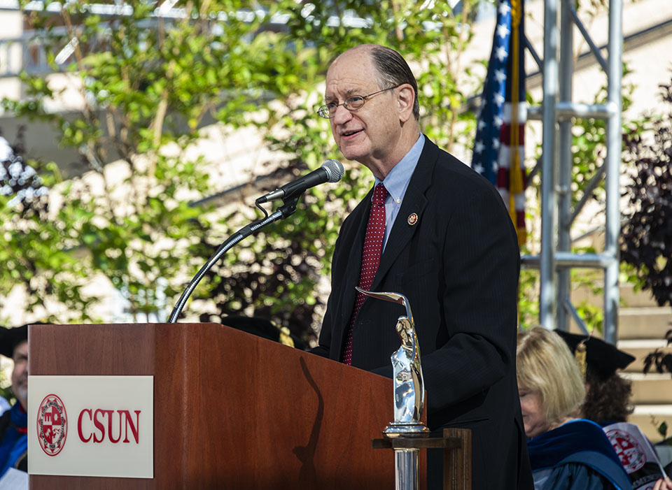 Congressman Brad Sherman stands at podium on stage, speaking to the Class of 2022 at Commencement.