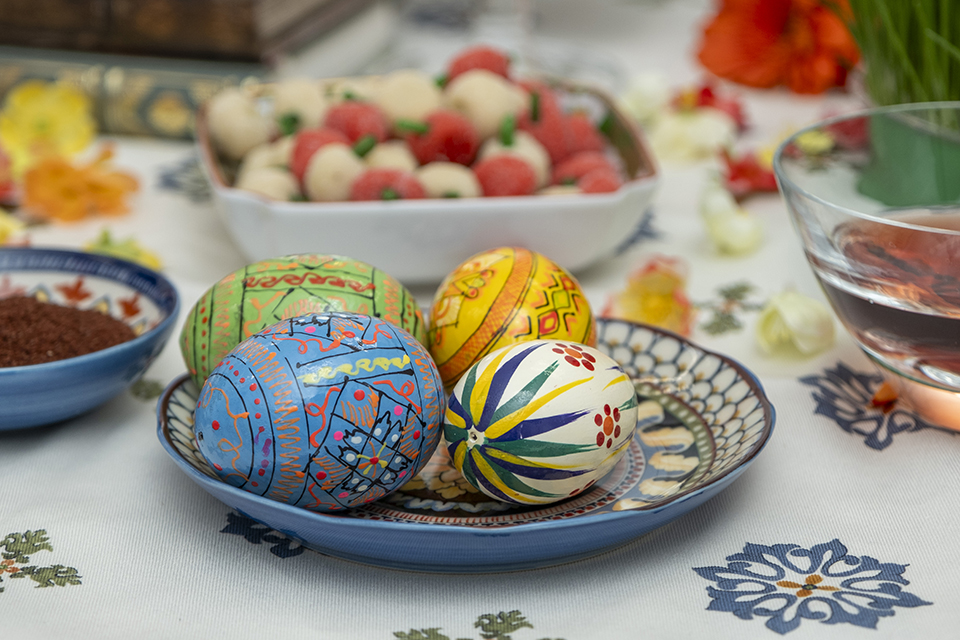 Painted eggs sit in a dish on the Haft Seen table