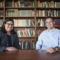 Chicana/o Studies professor Melisa Galván (left) and linguistics professor David Medeiros pose for a photo at a table.