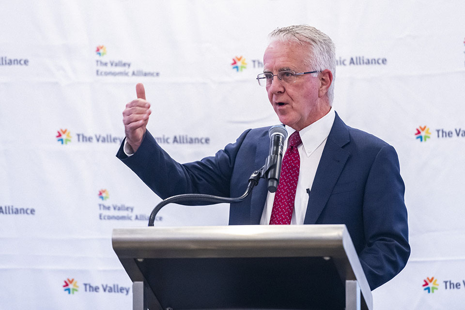 Paul Krekorian stands at a podium, gesturing with his right hand and speaking into a microphone.