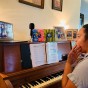 Pauline Tamale, a graduate music major in vocal performance, sits a piano to works with CSUN Opera Music Director Mercedes Juan Musotto (via a computer screen) to record a vocal for CSUN's upcoming animated opera.