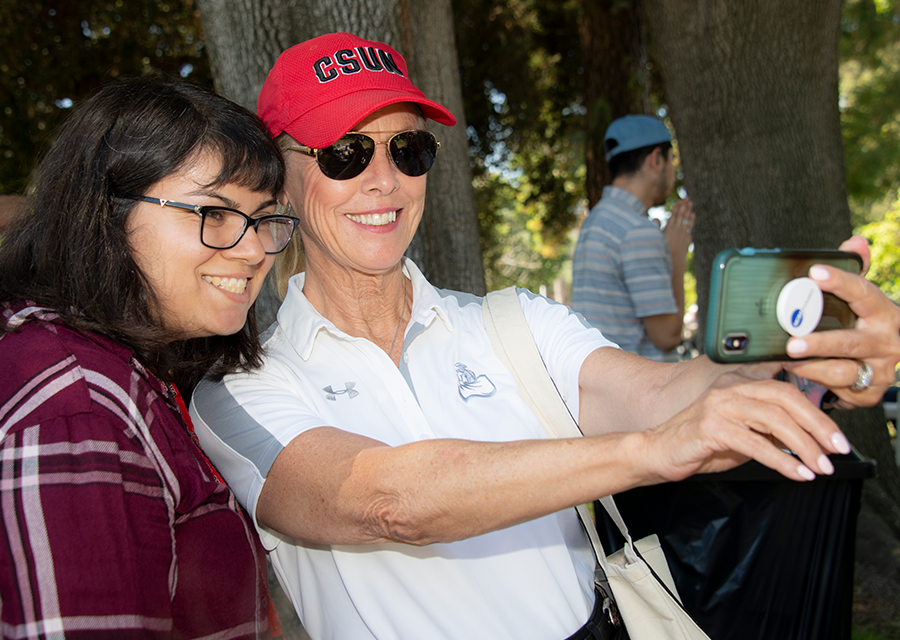 CSUN President Dianne F. Harrison smiles for a selfie with a student during the President's Picnic on the Bayramian Hall Lawn on Aug. 29.