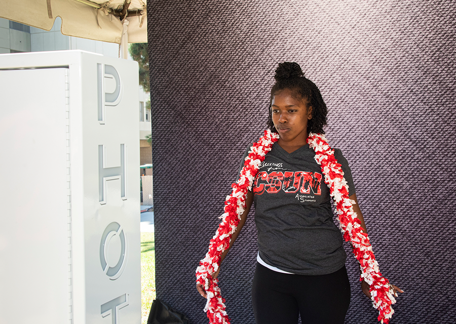 A student poses for a photo at the photo booth during the President's Picnic on the Bayramian Hall Lawn on Aug. 29.