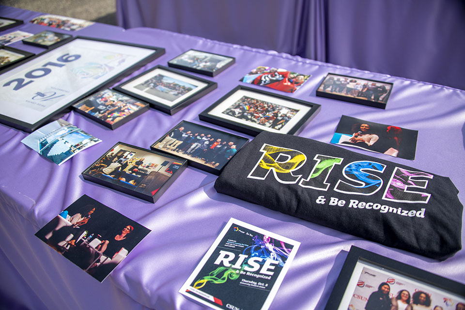 A table covered with a lavender, satin tablecloth and pictures, T-shirts and other mementos from the CSUN Pride Center's history.