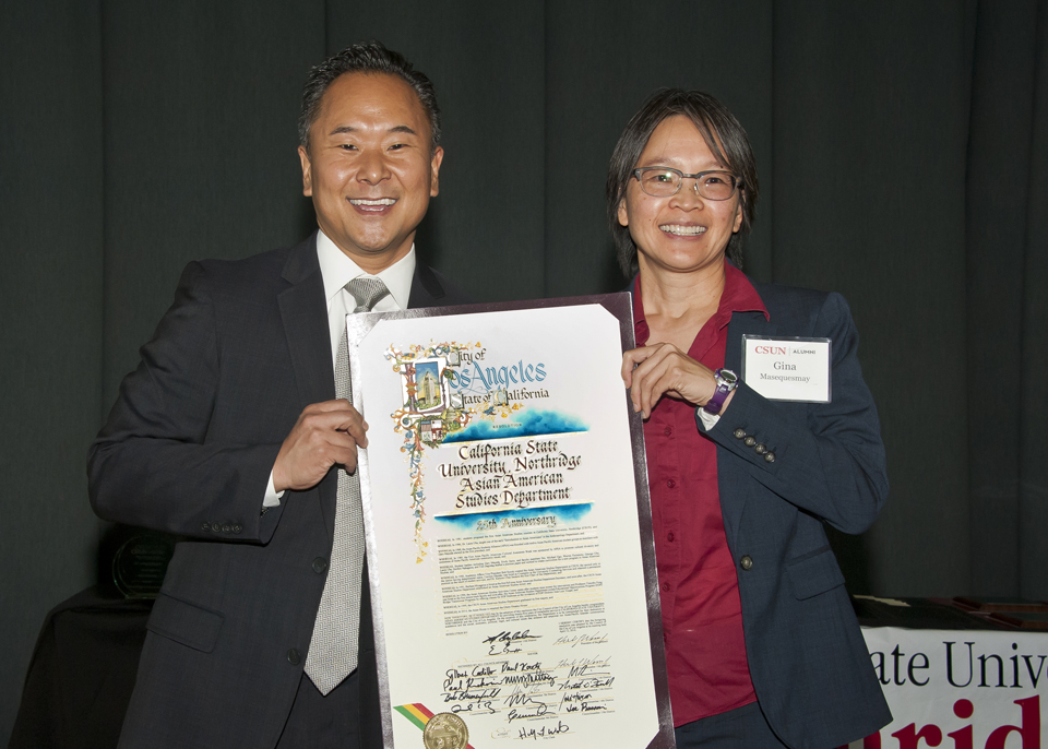 John Lee presents proclamation to Asian American studies chair Gina Masequesmay.