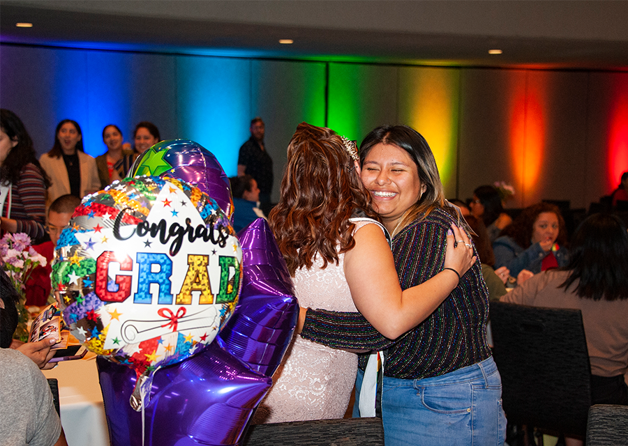 A student gets a warm hug from a friend at the Rainbow Graduation Celebration on May 17.