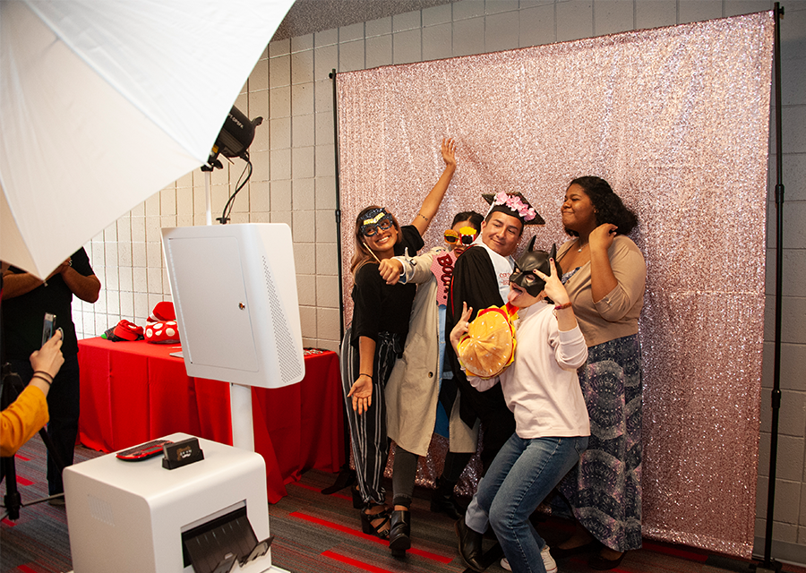 A graduating student poses for a silly photo with his friends at the photo booth during the Rainbow Graduation Celebration on May 17.