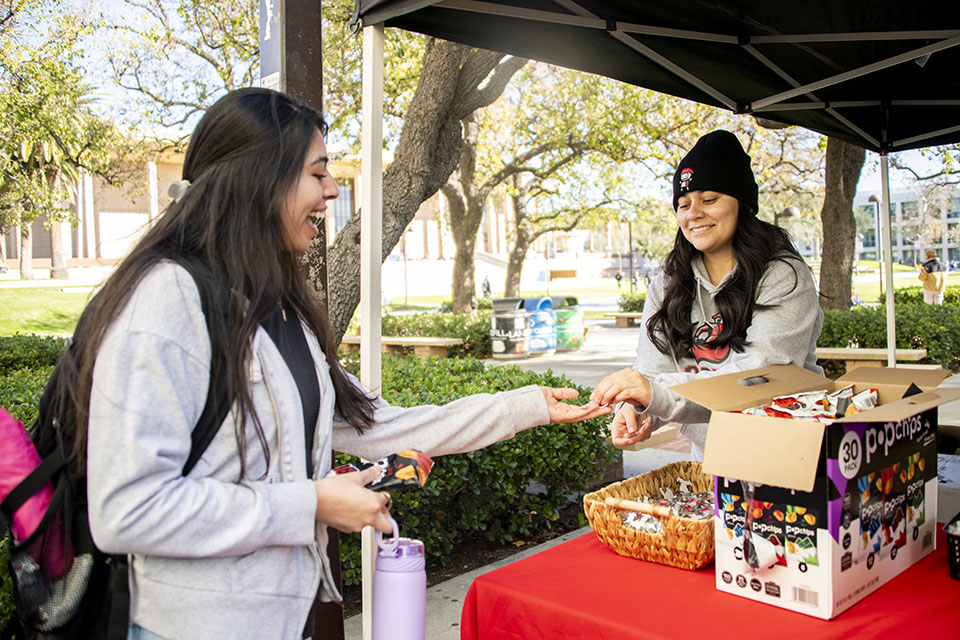 Student hands snack to other student at Welcome Week