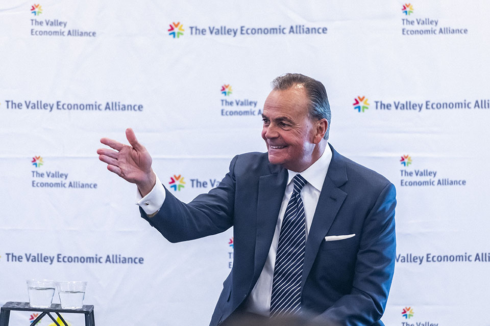 Rick Caruso smiles and gestures to an audience member.