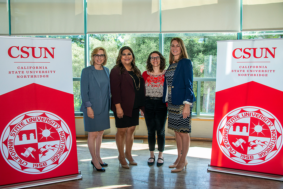 Wendy Greuel, Francesca M. Vega, Molly Rysman and Christina Miller pose between two CSUN banners.