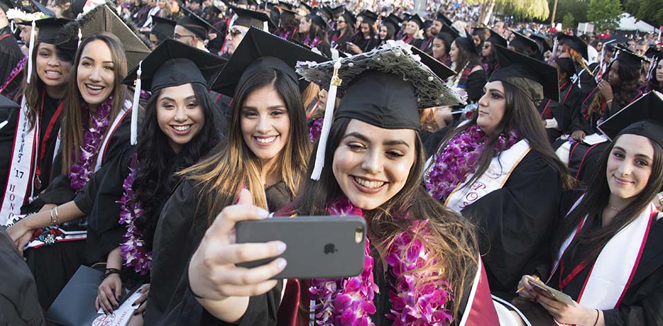 Students take selfie at commencement.