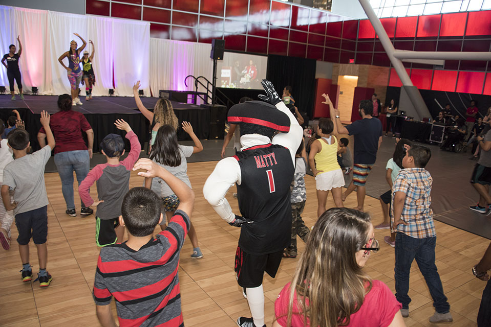 CSUN Matty the Matador, faculty, staff and their families participate in a Zumba session in front of the main stage.
