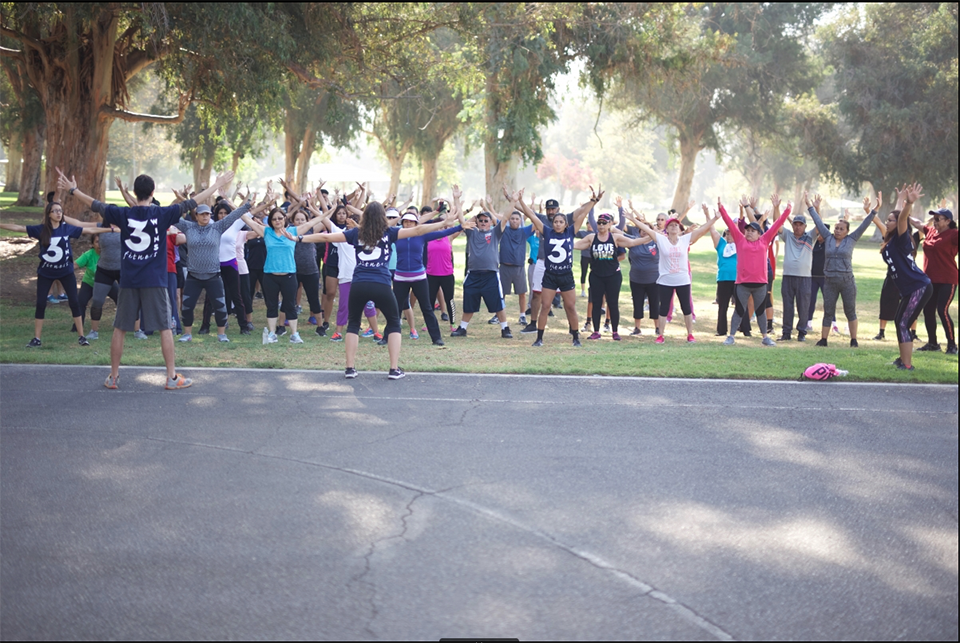 Instructors leads a group of participants in a fitness regimen.