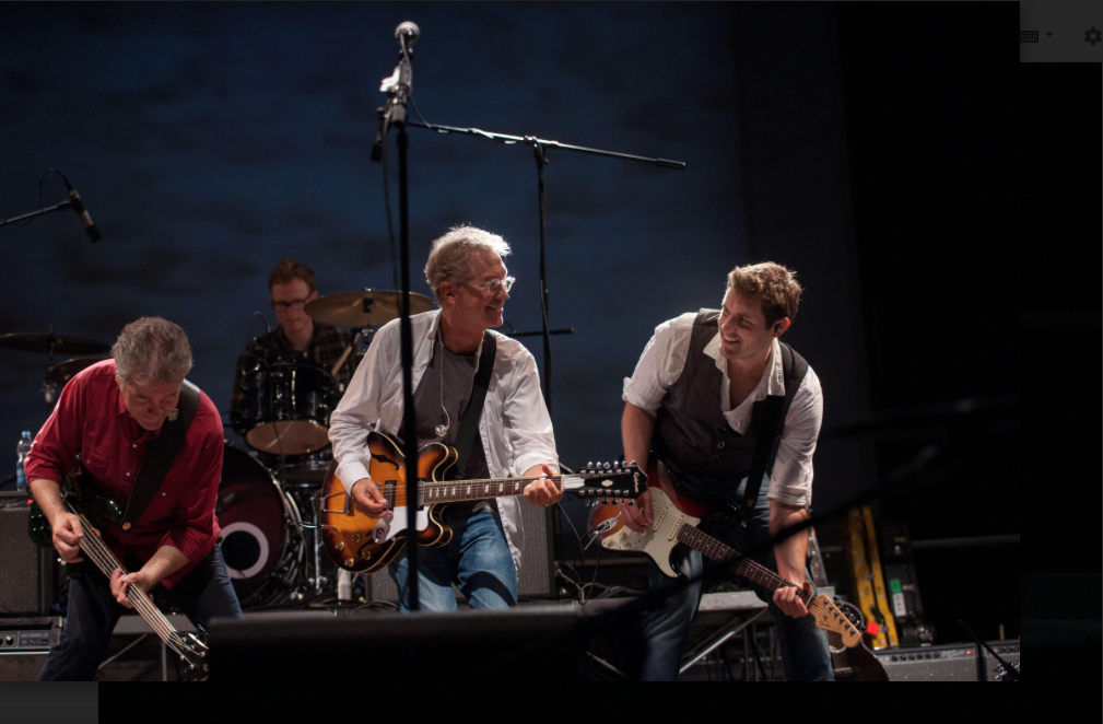 America band members Bill Worrell (far right), Gerry Beckley (center guitar) and Richard Cambell (far left) showing off their guitar skills on stage.