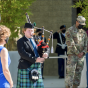 Soliders and onlookers bow their heads while a bagpipe player plays during a 9/11 20th anniversary ceremony at CSUN.
