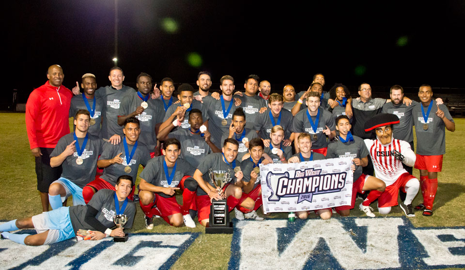 Group photo with CSUN Men's soccer team and Big West championship banner.