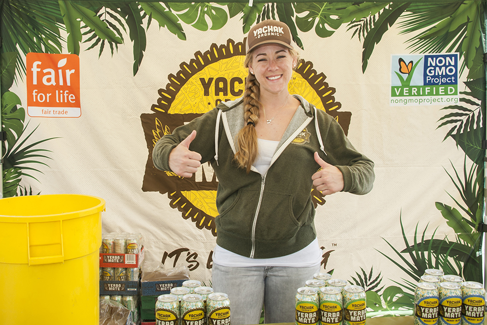 A vendor putting her thumbs up with yerba mate in front of her.