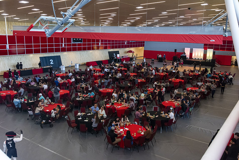 Numerous tables fill the MatArena in the Student Recreation Center and guests sit, eat and chat amongst themselves.