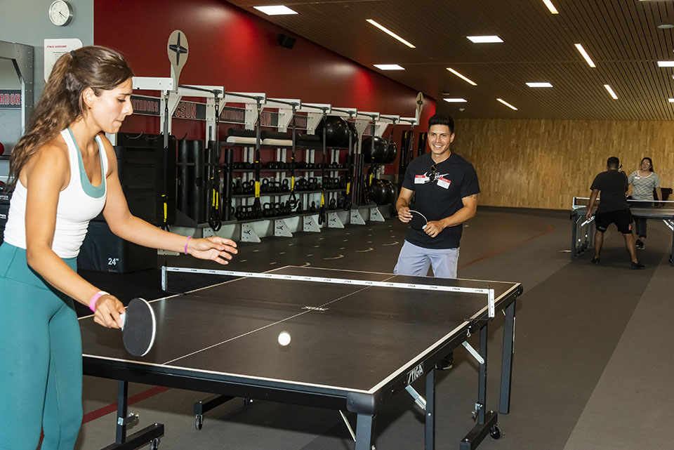 Two players play table tennis on the third floor of the Student Recreation Center.