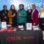 CSUN President Erika D. Beck stands with a group of CSUN leaders, alumni and students at a table decorated with a 