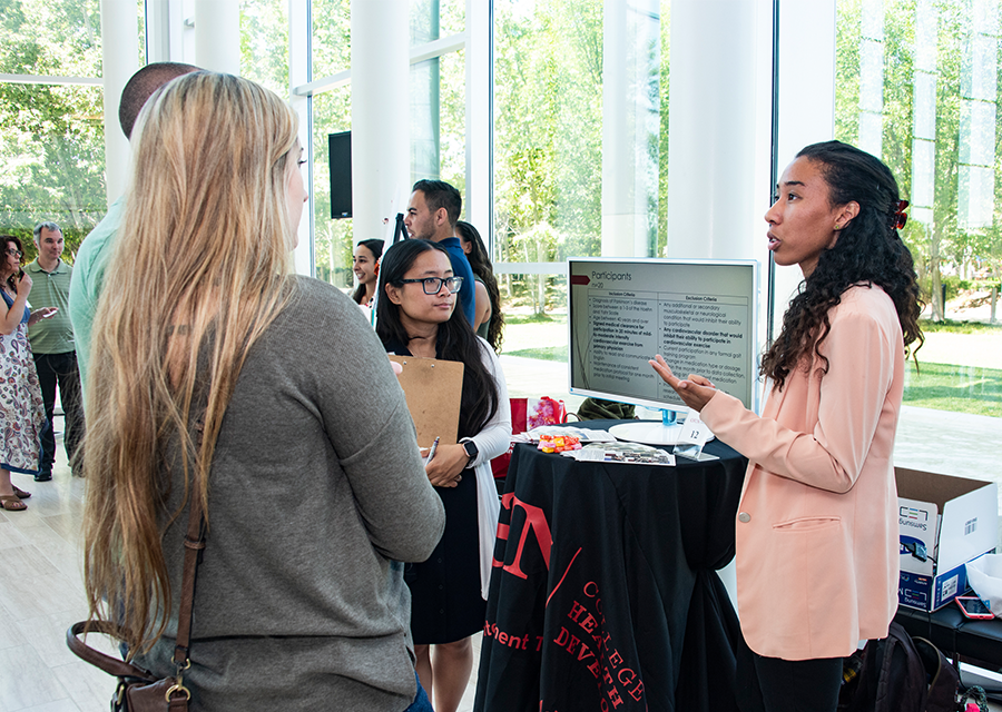 Attendees of the 2019 Annual Research and Service Learning Symposium learn more about Isabel Lorimer and Danica Marie Tolentino's kinesiology project, which won second-place for the Undergraduate Awards, on April 25, at the Great Hall of The Soraya.