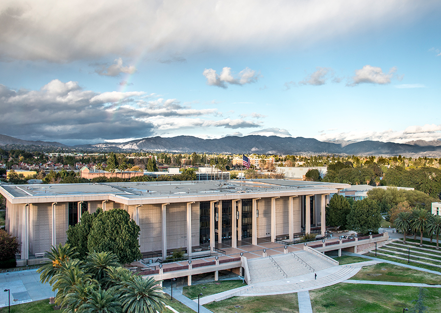 The Delmar T. Oviatt Library sits under a blue, partially cloudy sky.