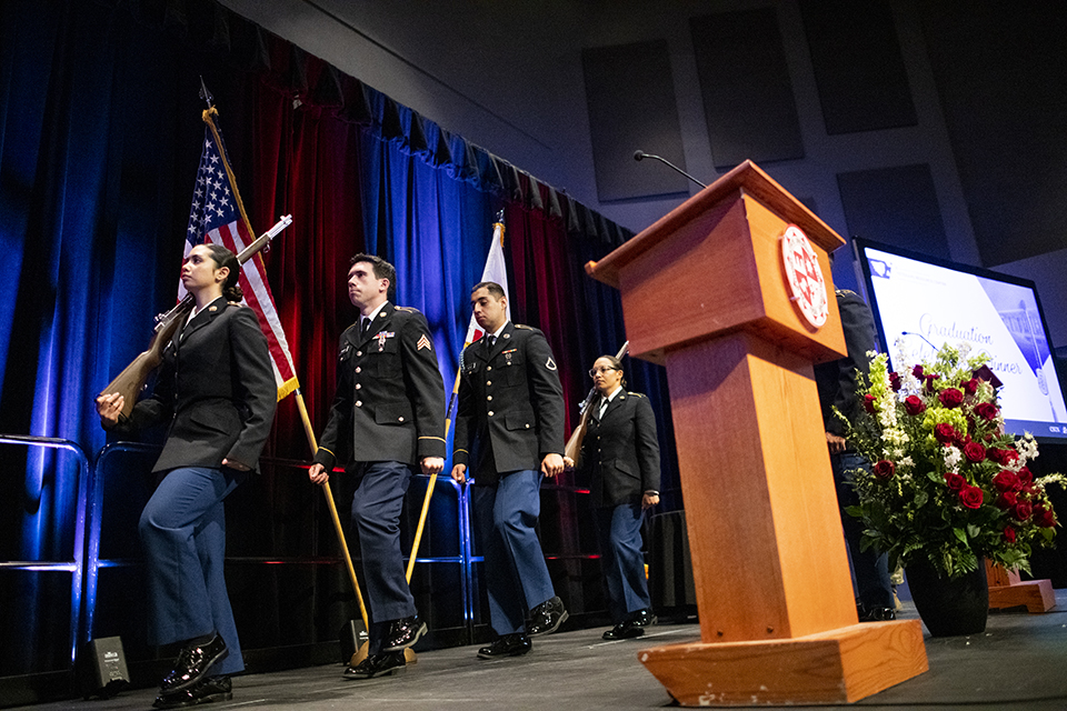 Color guard members in U.S. military uniforms leave the stage.
