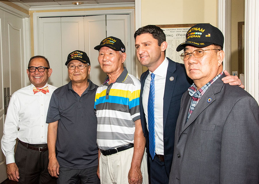Dr. Vito Imbasciani and Assemblymember Jesse Gabriel stand with three veterans.