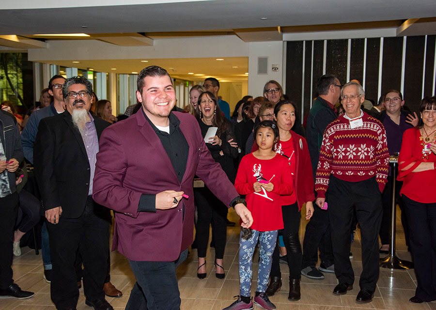 A man in a nice purple jacket on the dance floor at 2019 CSUN Winter Celebration.