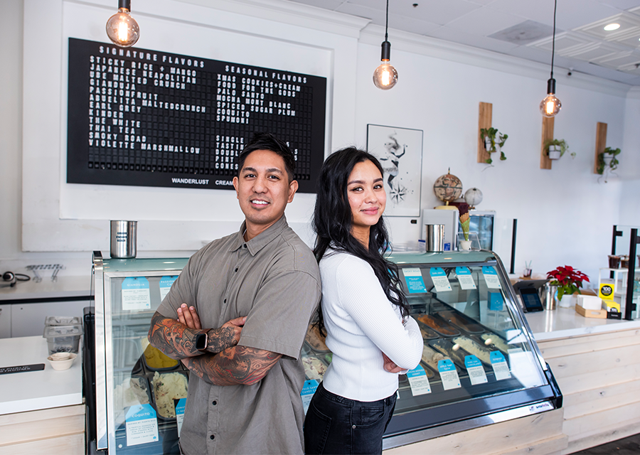 Jon-Patrick “JP” Lopez ’08 (Business Law) and Adrienne Borlongan '09 (Food Science) pose back-to-back in front of the counter of Wanderlust Creamery's Tarzana branch.