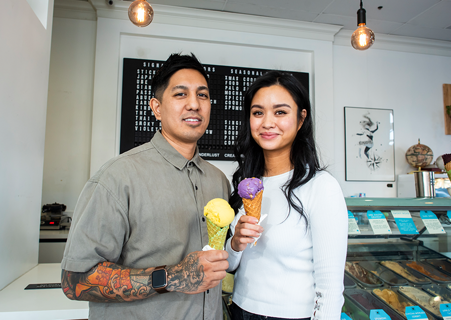 JP Lopez and Adrienne Borlongan smile for a photo with cones of Wanderlust Creamery ice cream.
