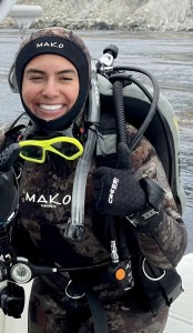 Student in full scuba diving gear smiles at the camera.