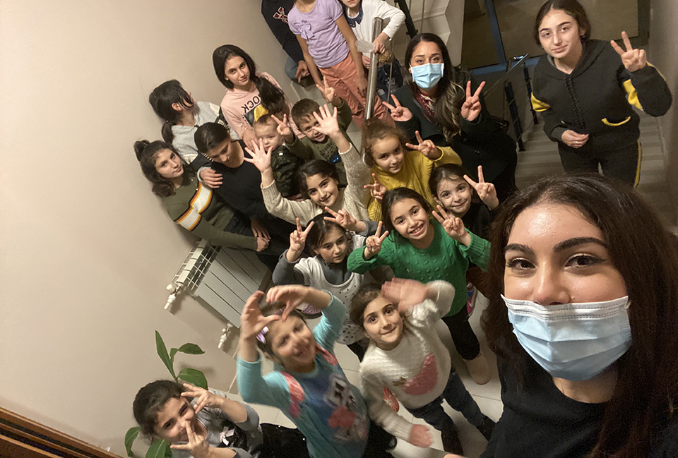 CSUN criminology and justice studies lecturer Megan Mangassarian, front right, with a group of displaced children at a refugee hotel in Armenia. Photo courtesy of Megan Mangassarian.