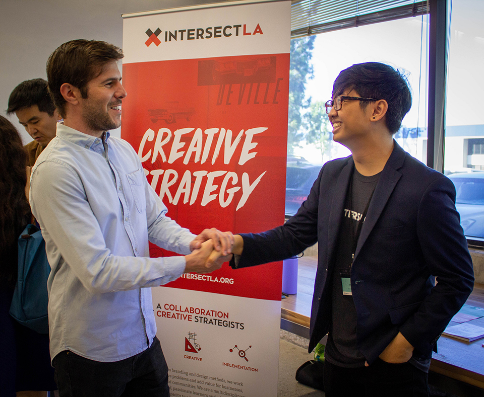 Student shaking hands with someone at a networking event.