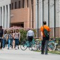 Several Students walk past locked up bikes.