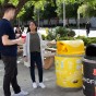 A CSUN student holds a reusable cup while another student disposes of compostable napkins in a compostable bin.