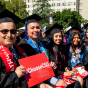 Graduates hold up a #ChooseCSU card and smile for a photo during Commencement 2019.