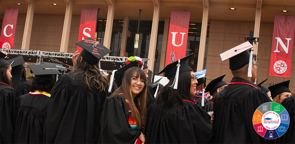 A group of graduating students with an Excelencia banner.