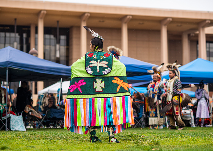 A woman showcases her regalia, which is adorned with dragonflies, at the 2019 CSUN Powwow.