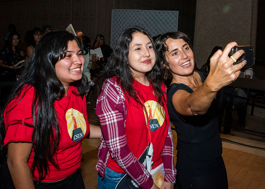Lauren Markham takes a selfie with two female CSUN students.